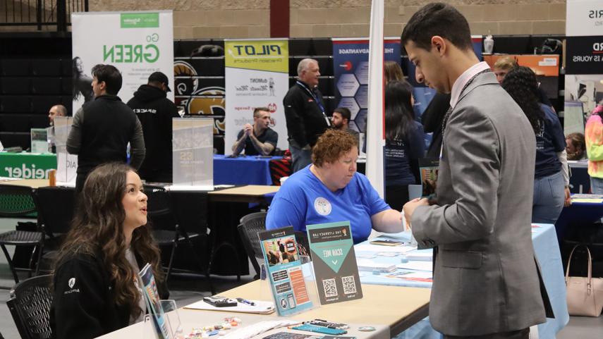 student speaking to recruiter at career fair